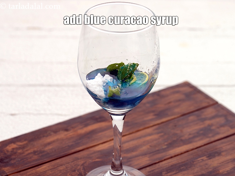 Step 8 – Add 2&frac12; tbsp blue&nbsp;<a href="https://www.tarladalal.com/glossary-curacao-1661i">curacao</a>&nbsp;syrup.