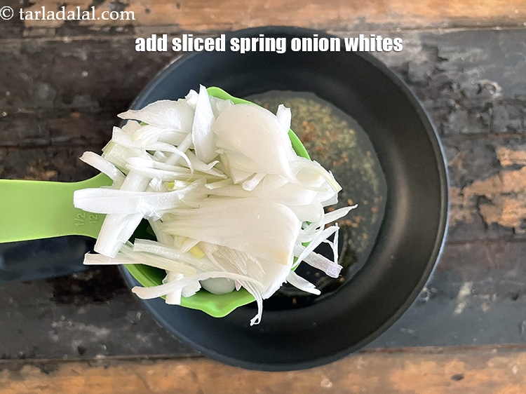 स्टेप 8 – १/२ कप <a href=""https://www.tarladalal.com/glossary-sliced-spring-onion-whites-hindi-818i"">स्लाईस्ड हरी प्याज़ का सफेद भाग</a> डालें।