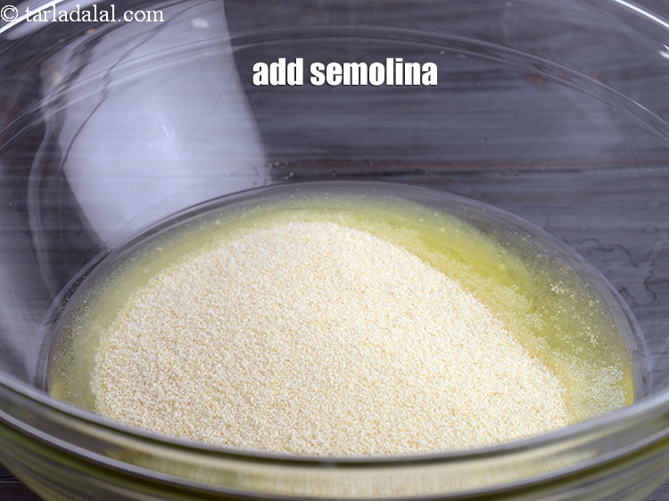 Step 8 – Add &frac12; cup <a href="https://www.tarladalal.com/glossary-semolina-sooji-rava-rawa-603i">semolina (rava / sooji)</a>.