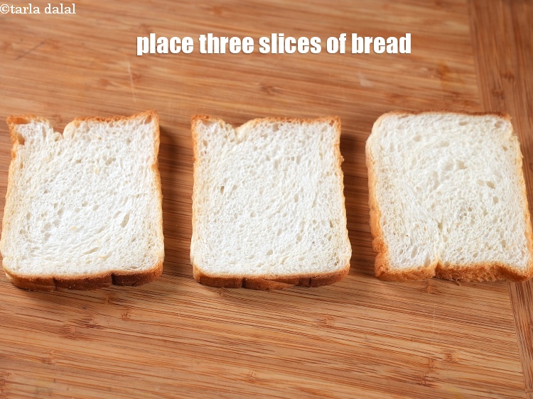 Step 9 – To make <strong>ghughra sandwich</strong>, place three slices of <a href="https://www.tarladalal.com/glossary-bread-219i">bread</a> on a clean dry surface.