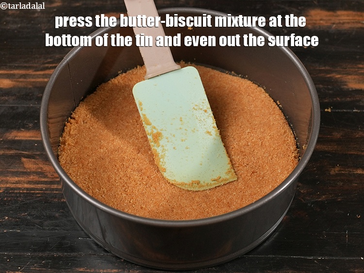 स्टेप 9 – मक्खन-बिस्किट मिश्रण को टिन के नीचे दबाएं और सतह को …