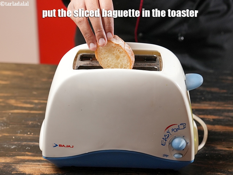 Step 10 – Put the <a href="https://www.tarladalal.com/glossary-sliced-baguette-1545i">sliced baguette</a> in the toaster.