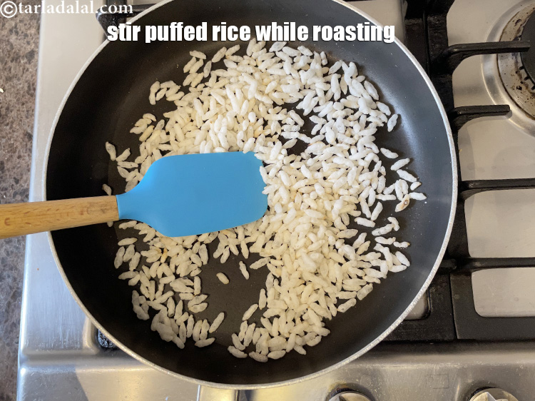 स्टेप 5 – मध्यम आंच पर भूनते समय मुरमुरे को एक स्पैटुला की …