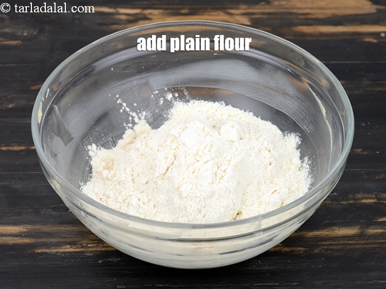 Step 9 – Add 1 cup <a href="https://www.tarladalal.com/glossary-plain-flour-maida-188i">plain flour (maida)</a>.