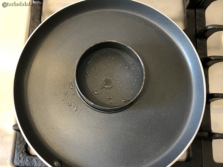 Step 9 – Place the &nbsp;loose &nbsp;bottom tin on a hot tava.