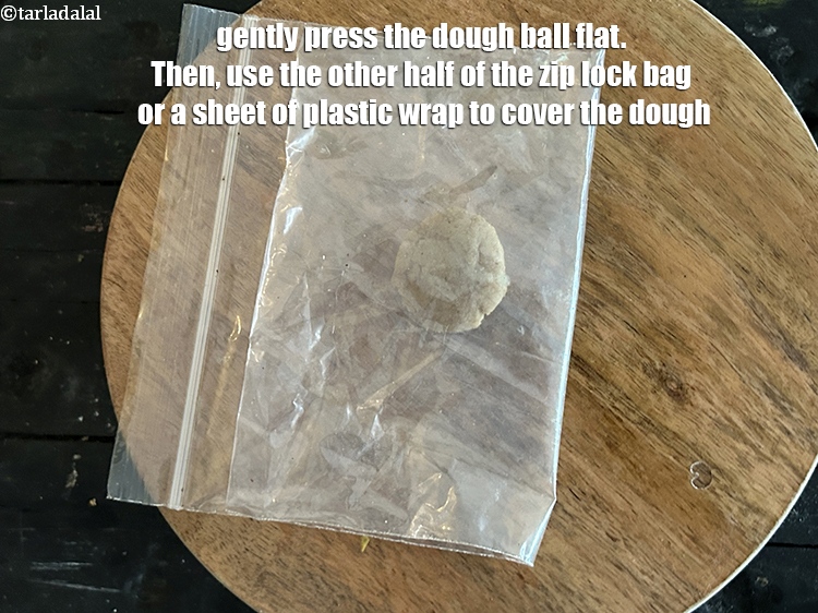 Step 10 – Gently press the dough ball flat. Then, use the other half of the zip lock …