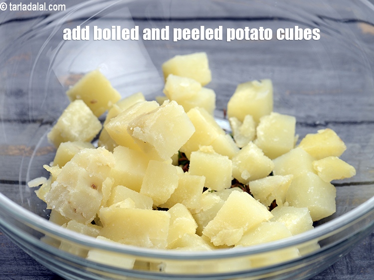Step 10 – Add 1 cup <a href="https://tarladalal.com/glossary-boiled-potato-cubes-2312i">boiled and peeled potato cubes</a>.