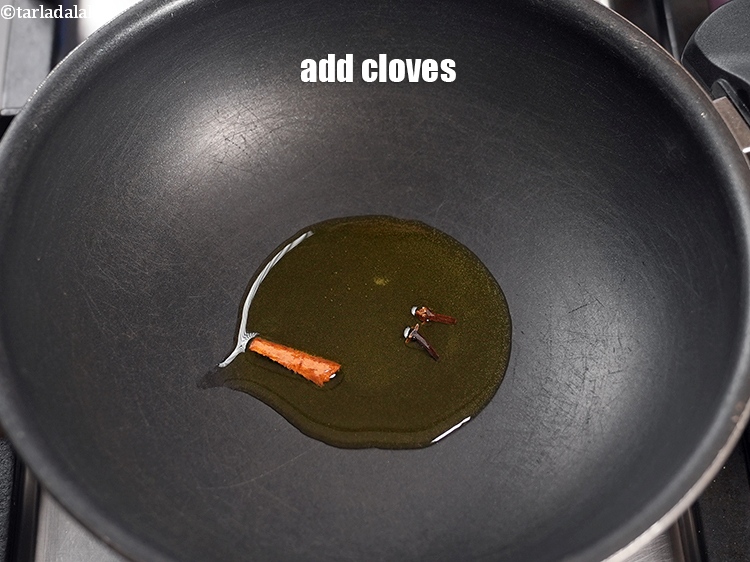 Step 10 – Add 2 <a href="https://www.tarladalal.com/glossary-cloves-laung-lavang-322i">cloves (laung / lavang)</a>.