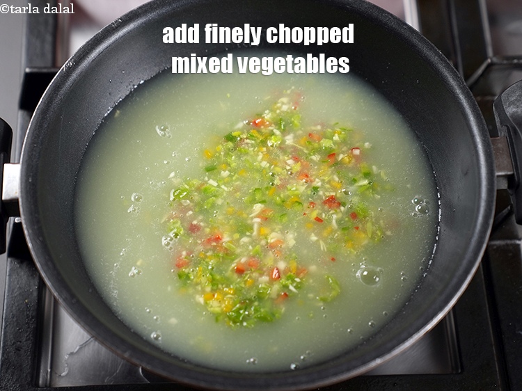 Step 10 – Add &frac12; cup finely <a href="https://www.tarladalal.com/glossary-chopped-mixed-vegetables-782i">chopped mixed vegetables</a>&nbsp;(french beans , cabbage , coloured capsicum , …