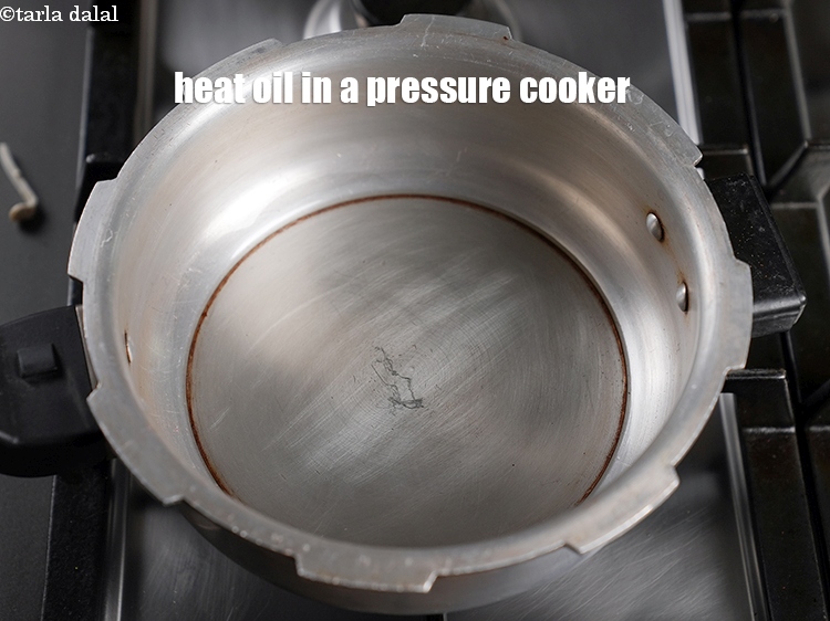 Step 10 – To make <strong>tariwale aloo mutter</strong>, heat 2 tbsp oil&nbsp;&nbsp;in a pressure cooker.