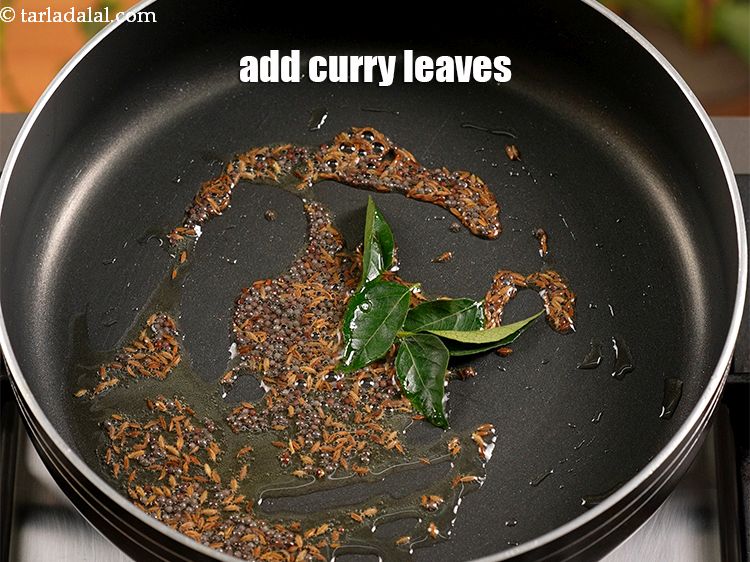 Step 10 – When the seeds crackle, add 4 to 5 curry leaves.