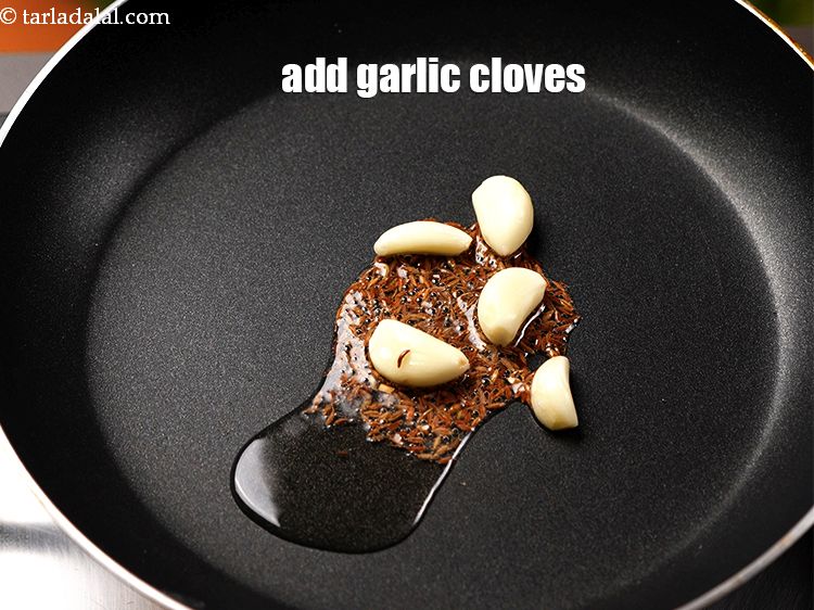 Step 10 – Add 5 <a href="https://www.tarladalal.com/glossary-garlic-cloves-1857i">garlic (lehsun) cloves</a>.