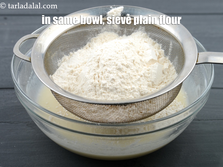 Step 10 – In the same bowl, sieve 1 cup&nbsp;<a href="https://www.tarladalal.com/glossary-plain-flour-maida-188i">plain flour (maida)</a>.