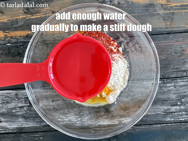 Step 10 – <u><em>Add enough water gradually to make a stiff dough. We added 1/4 cup water first …
