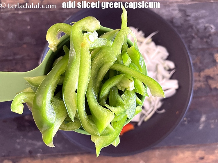 स्टेप 10 – १/२ कप <a href=""https://www.tarladalal.com/glossary-sliced-capsicum-hindi-165i"">स्लाईस्ड हरी शिमला मिर्च</a> डालें।