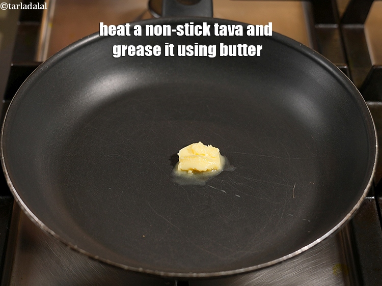 Step 11 – Heat a non-stick tava (griddle) and grease it using &frac12; tsp of butter.