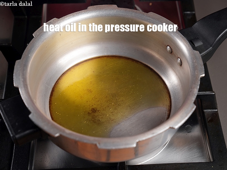 Step 11 – To make <strong>kathal ki sabzi</strong>, heat 2 tbsp oil in the pressure cooker.