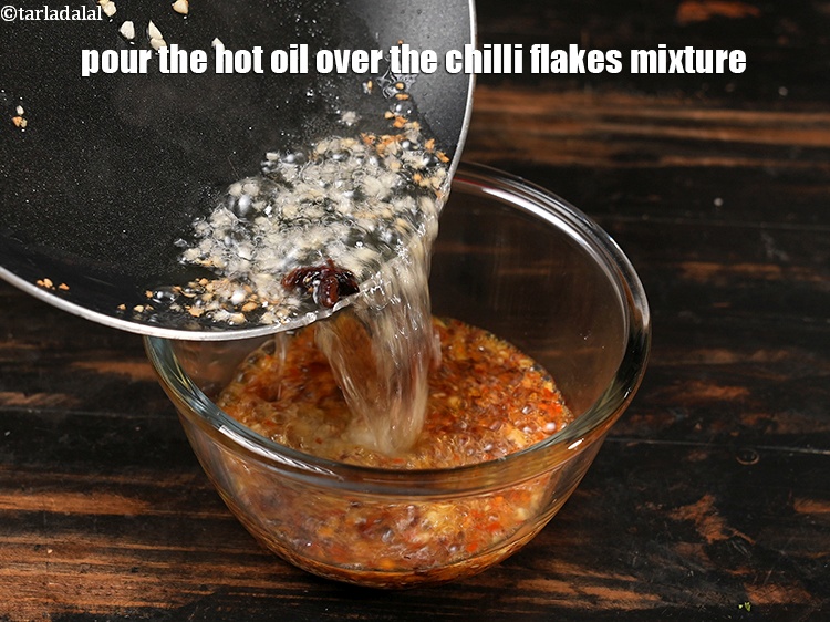 स्टेप 11 – गरम तेल को मिर्च के मिश्रण पर डालें।