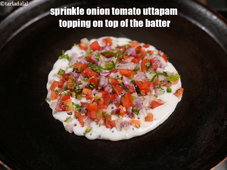 स्टेप 42 – बैटर के ऊपर <strong>प्याज टमाटर उत्तपम</strong> के टॉपिंग का १/७वां …