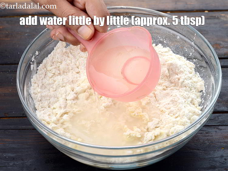 स्टेप 13 – थोड़ा-थोड़ा करके पानी डालें, हमने लगभग ५ टेबलस्पून पानी का …