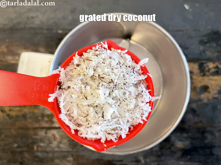 स्टेप 11 – १/४ कप <a href=""https://www.tarladalal.com/glossary-grated-dry-coconut-hindi-2272i"">कसा हुआ सूखा नारियल</a> में डालें।