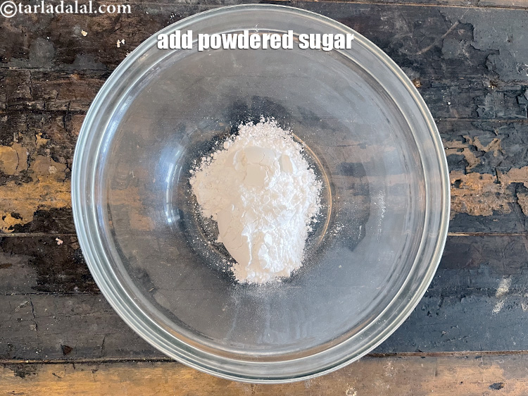 स्टेप 56 – एक गहरे बाउल में १/२ कप <a href=""https://www.tarladalal.com/glossary-powdered-sugar-hindi-280i"" target=""_blank"">पिसी हुई …