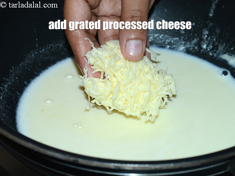 Step 14 – Add &frac12; cup <a href="https://www.tarladalal.com/glossary-grated-processed-cheese-868i">grated processed cheese</a>.