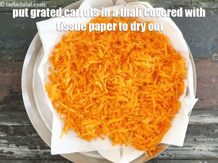 Step 13 – Place the grated carrots in a thali covered with tissue to dry out the water.