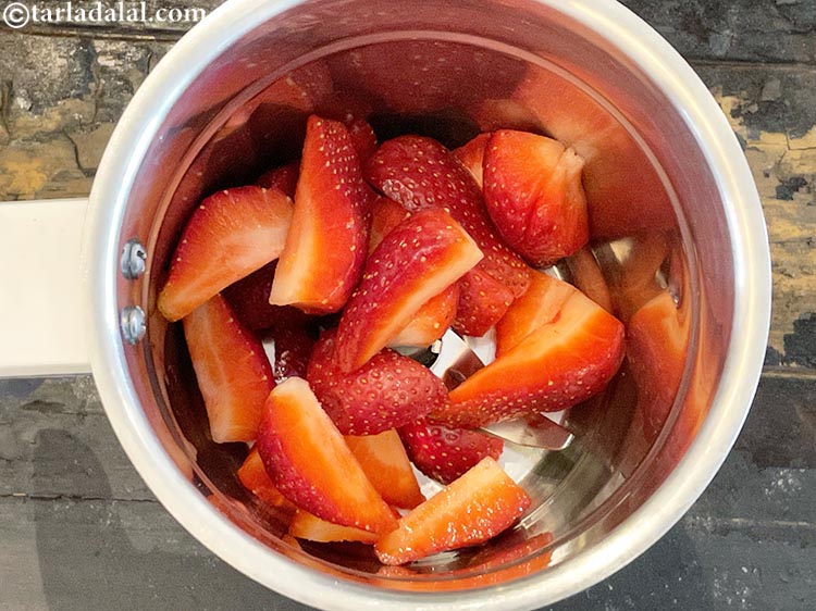 Step 4 – To make<strong> strawberry milkshake</strong>, in a blender jar take chopped strawberries.&nbsp;