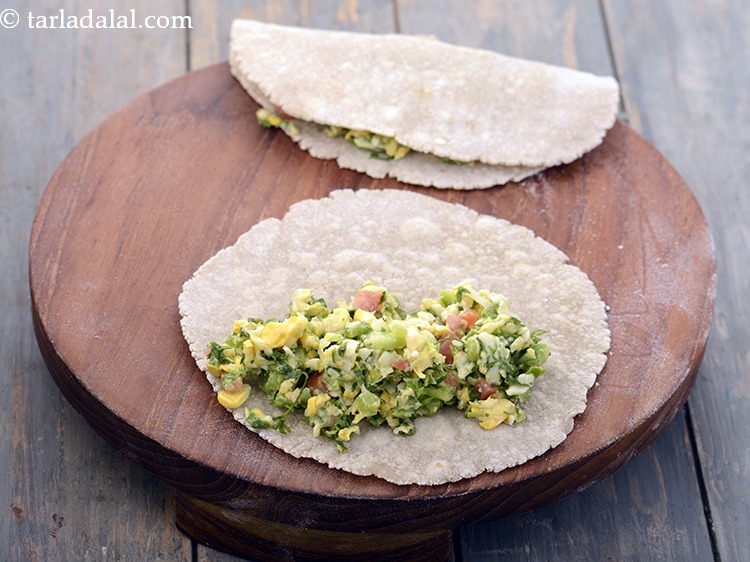 Step 19 – Spread a portion of the prepared stuffing on half of the roti and fold it …