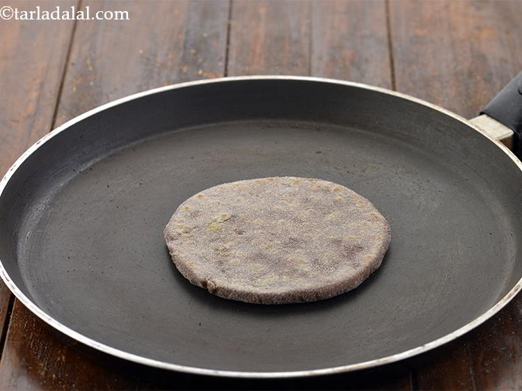 Step 24 – Heat the non-stick tava (griddle), place the&nbsp;&nbsp;<strong>Stuffed Nachni Roti with cauliflower, methi and karela</strong>&nbsp;over it.