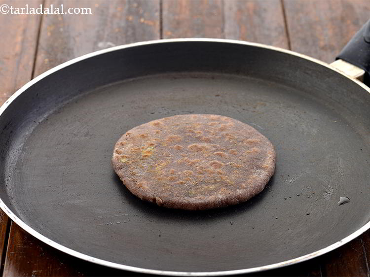 Step 25 – Cook one side till little brown and flip the&nbsp;<strong>Stuffed Nachni Roti</strong>&nbsp;over.