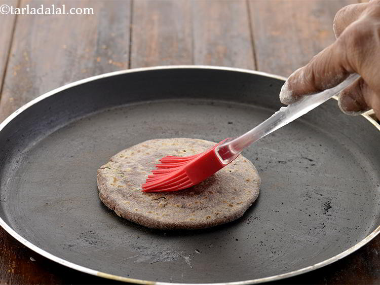 Step 26 – Now, using &frac12; tsp peanut oil/ghee, cook the&nbsp;&nbsp;<strong>Stuffed Nachni Roti with cauliflower, methi and karela</strong>&nbsp;on …