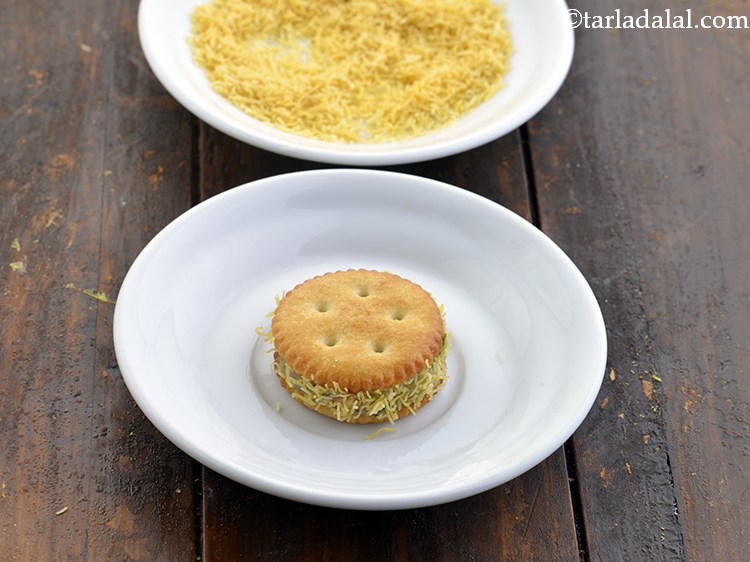 Step 15 – Roll the prepared stuffed biscuit in sev and coat it evenly from all sides.