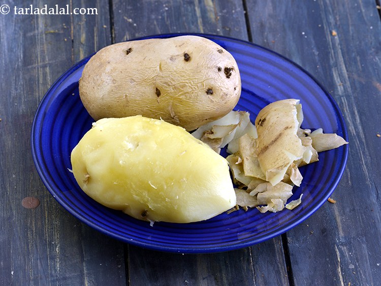 स्टेप 7 – आलू छीलें और छिलकों को निकाल दें।