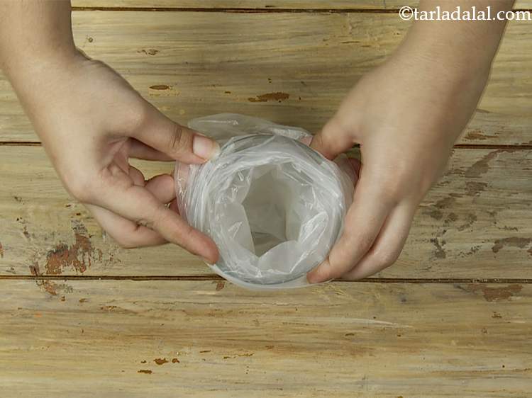 Step 14 – Take a glass, arrange a disposable plastic piping bag in it.