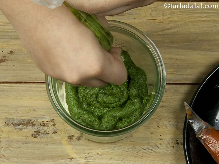 Step 23 – Snip off the tip of the pesto piping bag. Top the cream cheese layer with …