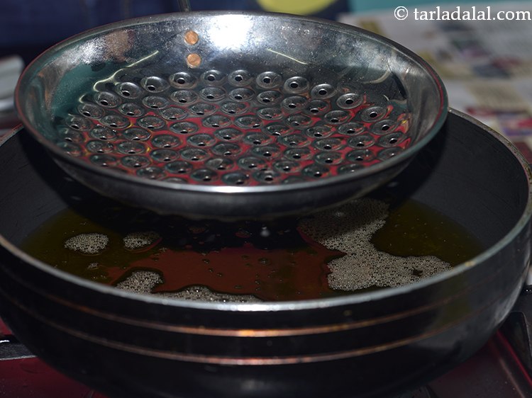 Step 15 – Now hold one perforated spoon (boondi jhara) just over ghee. If it is too high, …