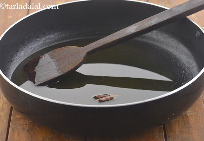 Step 17 – Heat the ghee in a broad non-stick pan and add the cinnamon stick.