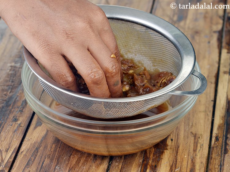 Step 19 – Strain the imli pulp using a strainer in another deep bowl. The seeds and the …