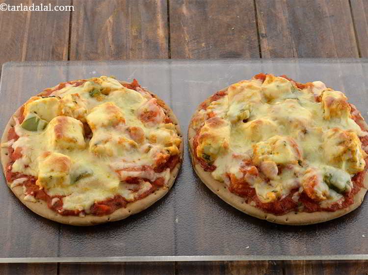स्टेप 24 – दोनो <strong>तंदूरी पनीर पिज़्ज़ा</strong> को चुपड़ी हुई बेकिंग ट्रे पर …