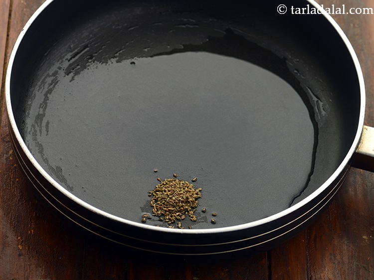 Step 2 – Once the oil is hot, add the carom seeds and allow them to crackle.