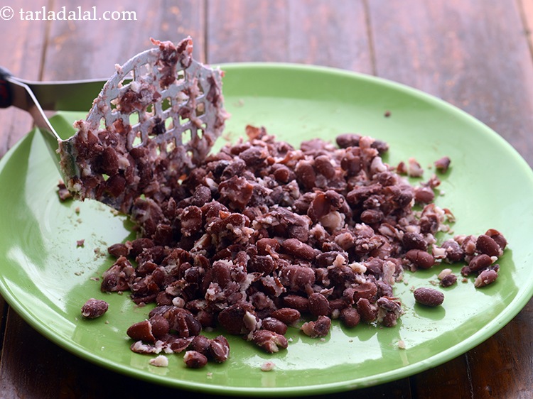 Step 19 – Transfer to plate and coarsely crush the rajma using a potato masher.