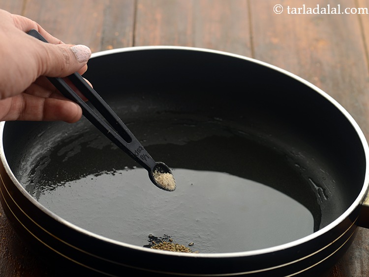 Step 3 – When the seeds crackle, add the asafoetida.