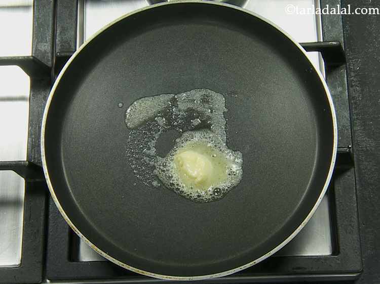 Step 13 – Heat a non-stick tava/tawa (griddle) , put 1 tsp of butter on it.