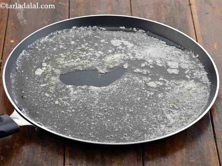 Step 17 – For <strong>the Mumbai roadside tawa pulao recipe</strong>, heat the butter on a large tava (griddle). …