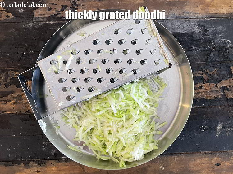Step 7 – Hold a vegetable grater in one hand and the bottle gourd on the other. Starting …