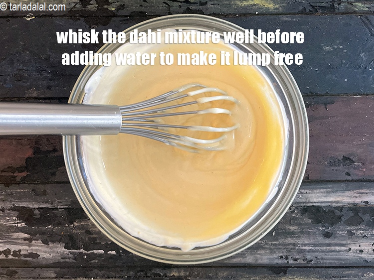 स्टेप 26 – दही मिश्रण को गांठ रहित बनाने के लिए उसमें पानी …