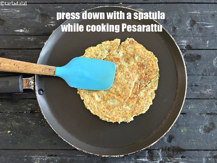 Step 23 – <meta charset="UTF-8" />Press down gently with a spatula while cooking <strong>Moong Sprouts Pesarattu</strong>.