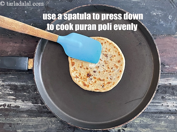 Step 41 – Use a spatula to press down to cook puran poli evenly.&nbsp;&nbsp;